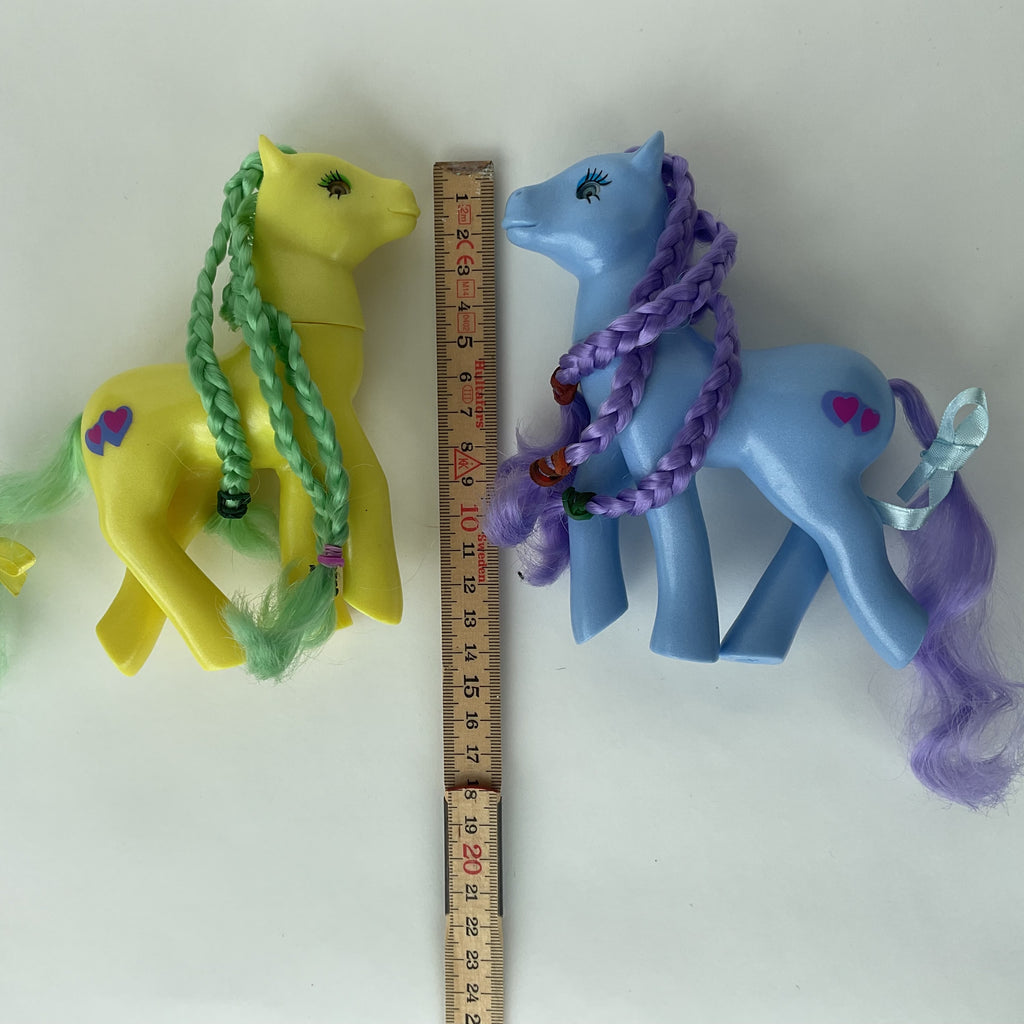 2 søde ponyfigurer med flettet hår – gul/grøn og blå/lilla – ca. 14 cm