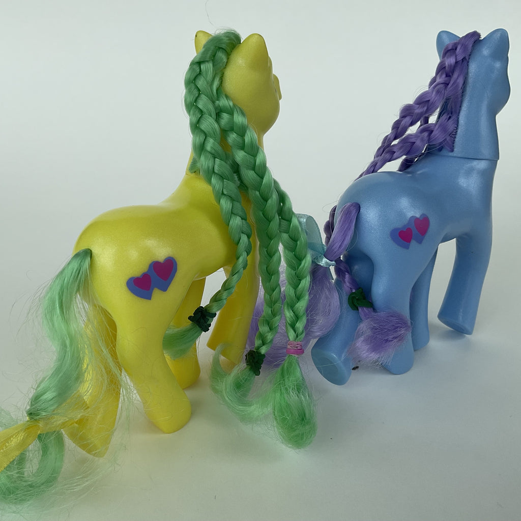 2 søde ponyfigurer med flettet hår – gul/grøn og blå/lilla – ca. 14 cm