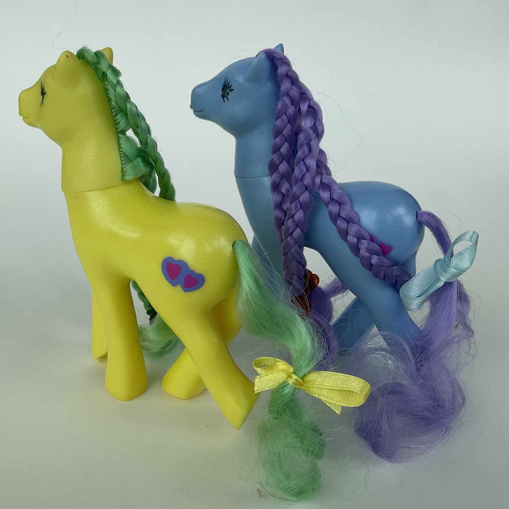 2 søde ponyfigurer med flettet hår – gul/grøn og blå/lilla – ca. 14 cm