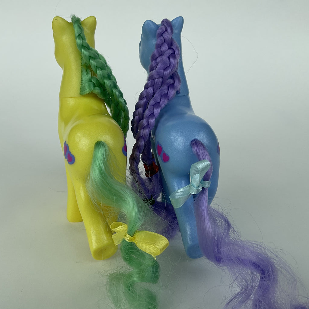 2 søde ponyfigurer med flettet hår – gul/grøn og blå/lilla – ca. 14 cm