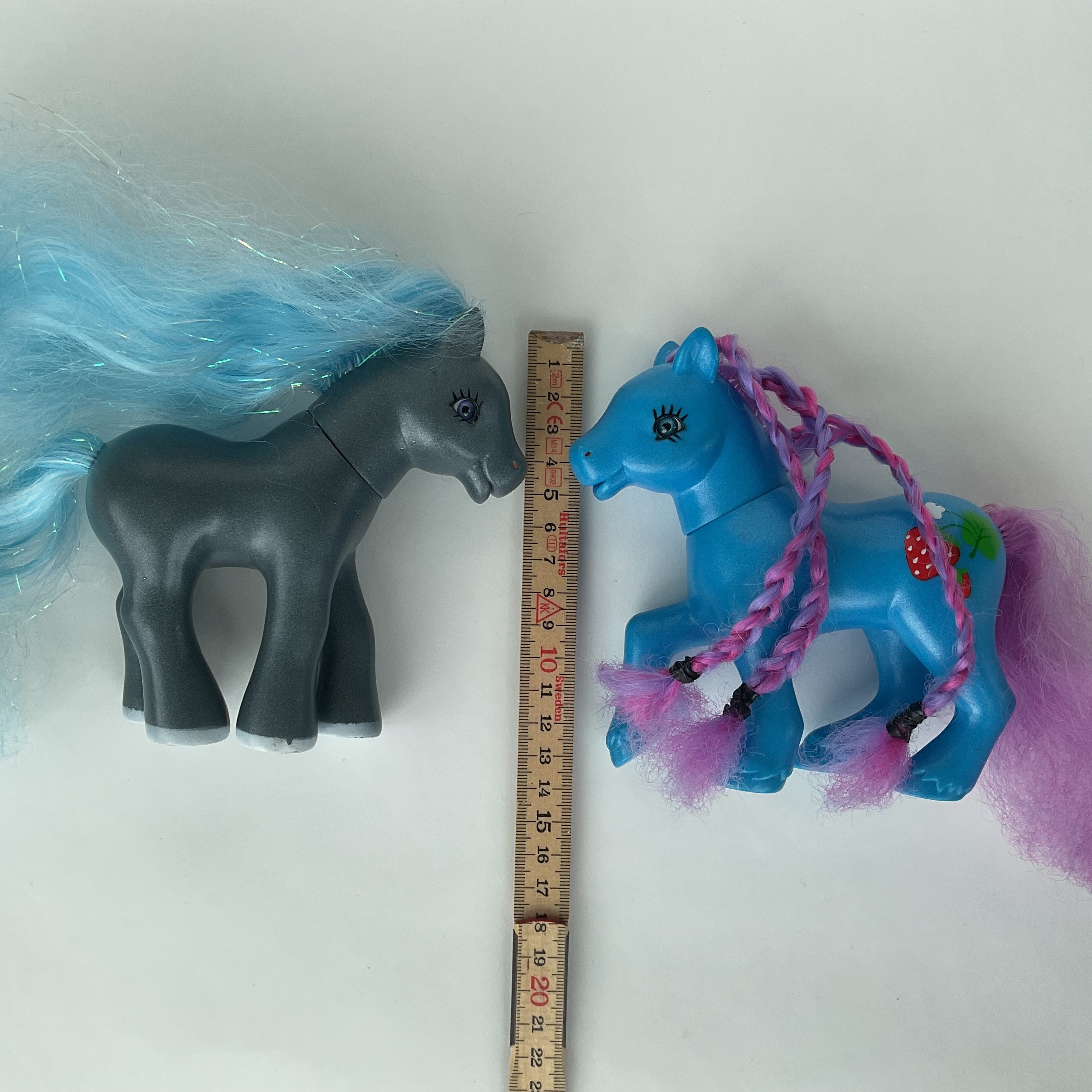 2 flotte ponyfigurer med farverigt hår – blå/lilla og grå/blå – ca. 14 cm