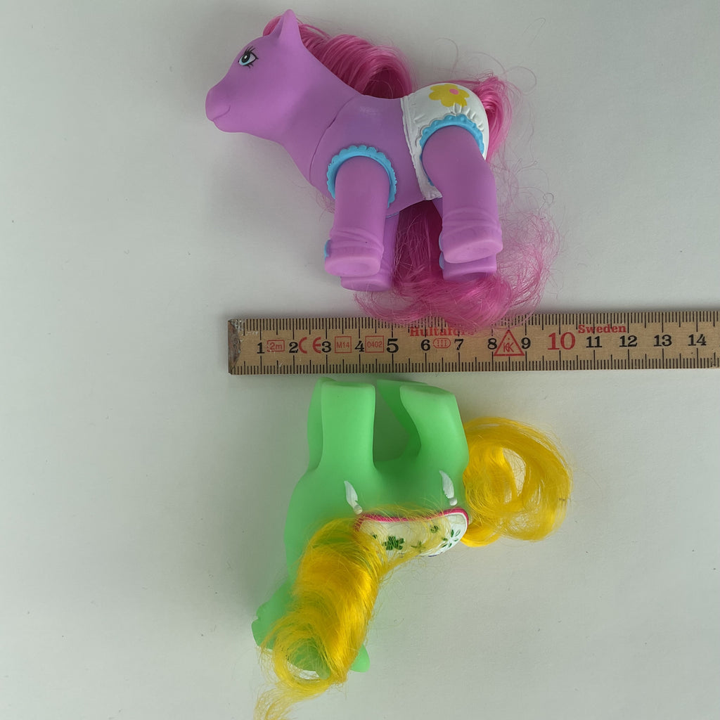 2 søde ponyfigurer med farverige detaljer – grøn/gul og lilla/pink – ca. 9 cm