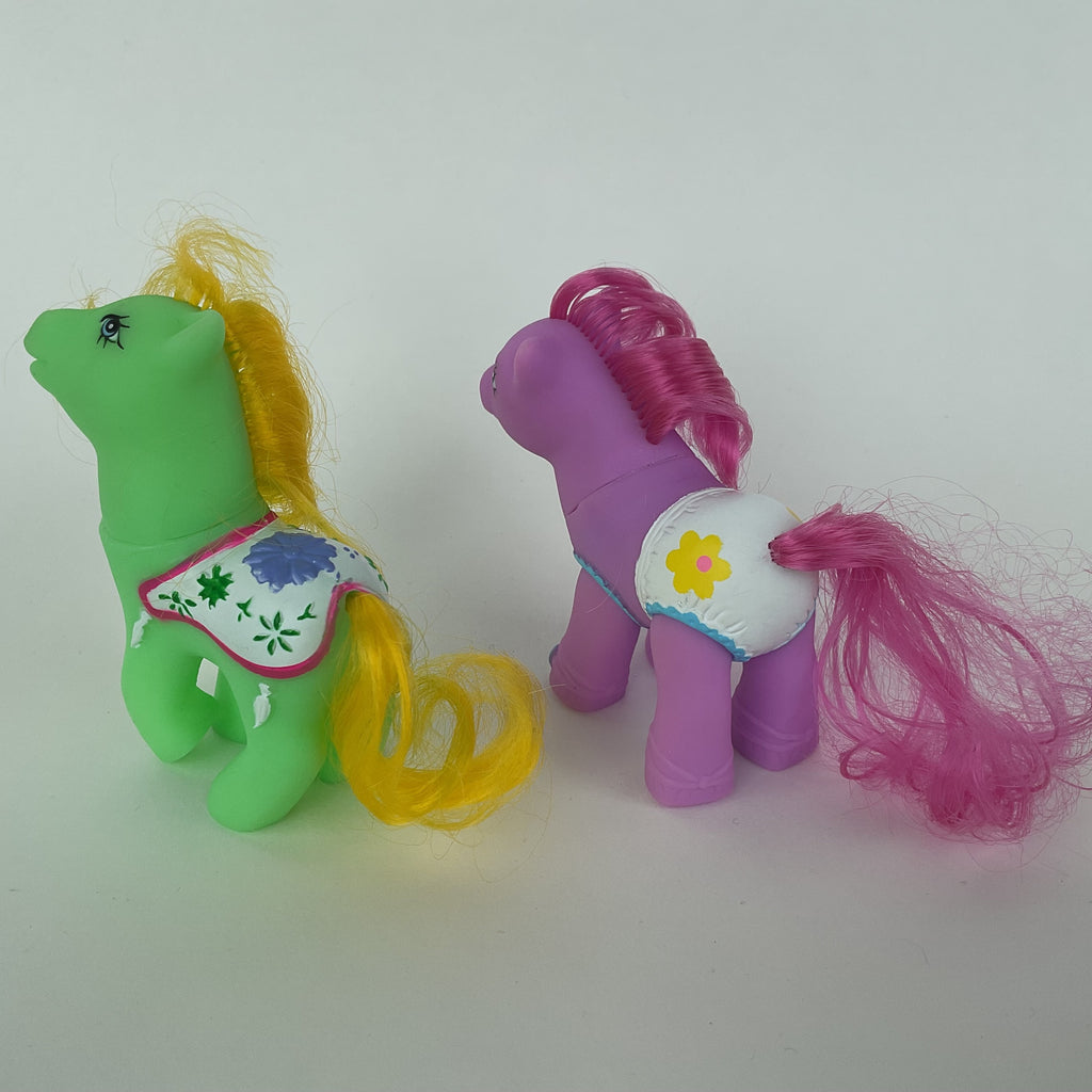 2 søde ponyfigurer med farverige detaljer – grøn/gul og lilla/pink – ca. 9 cm