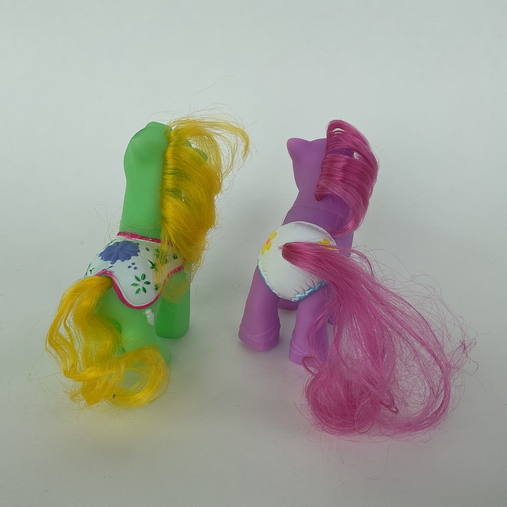 2 søde ponyfigurer med farverige detaljer – grøn/gul og lilla/pink – ca. 9 cm