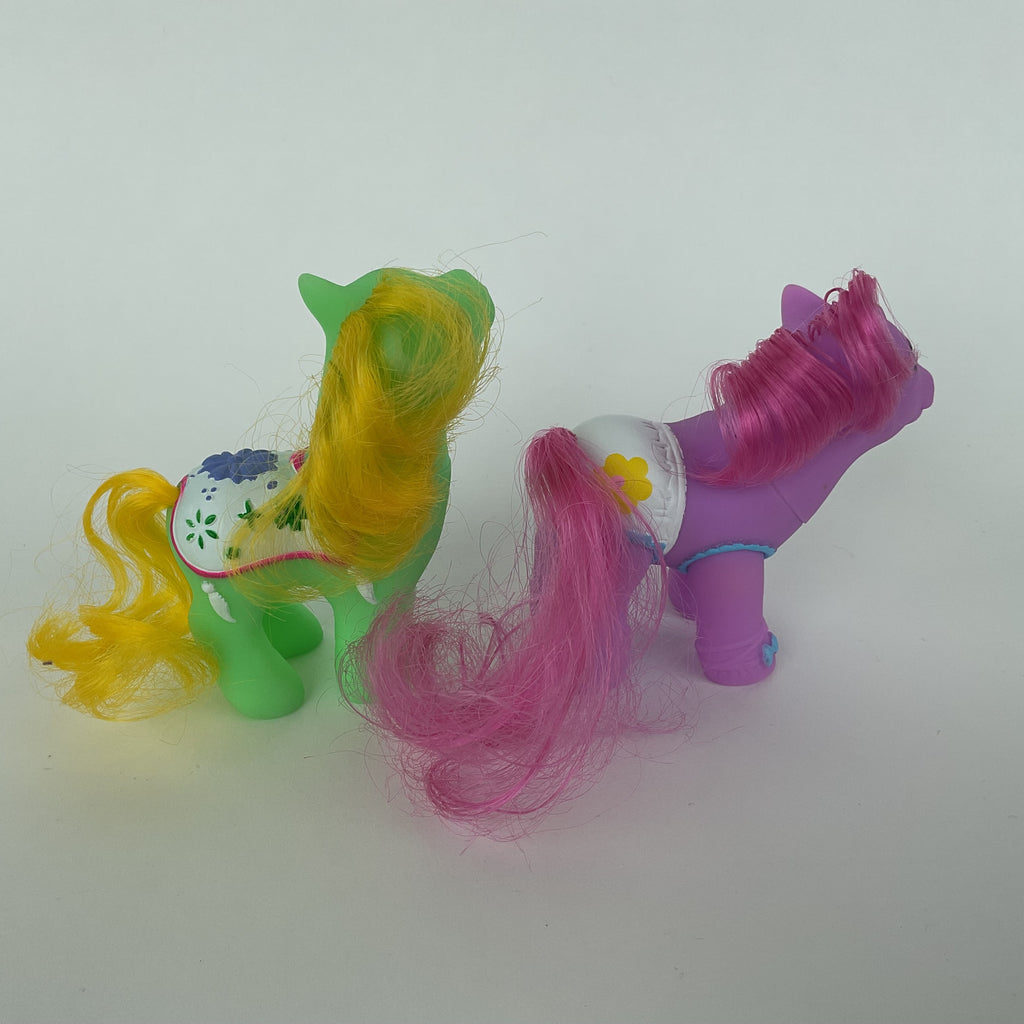 2 søde ponyfigurer med farverige detaljer – grøn/gul og lilla/pink – ca. 9 cm