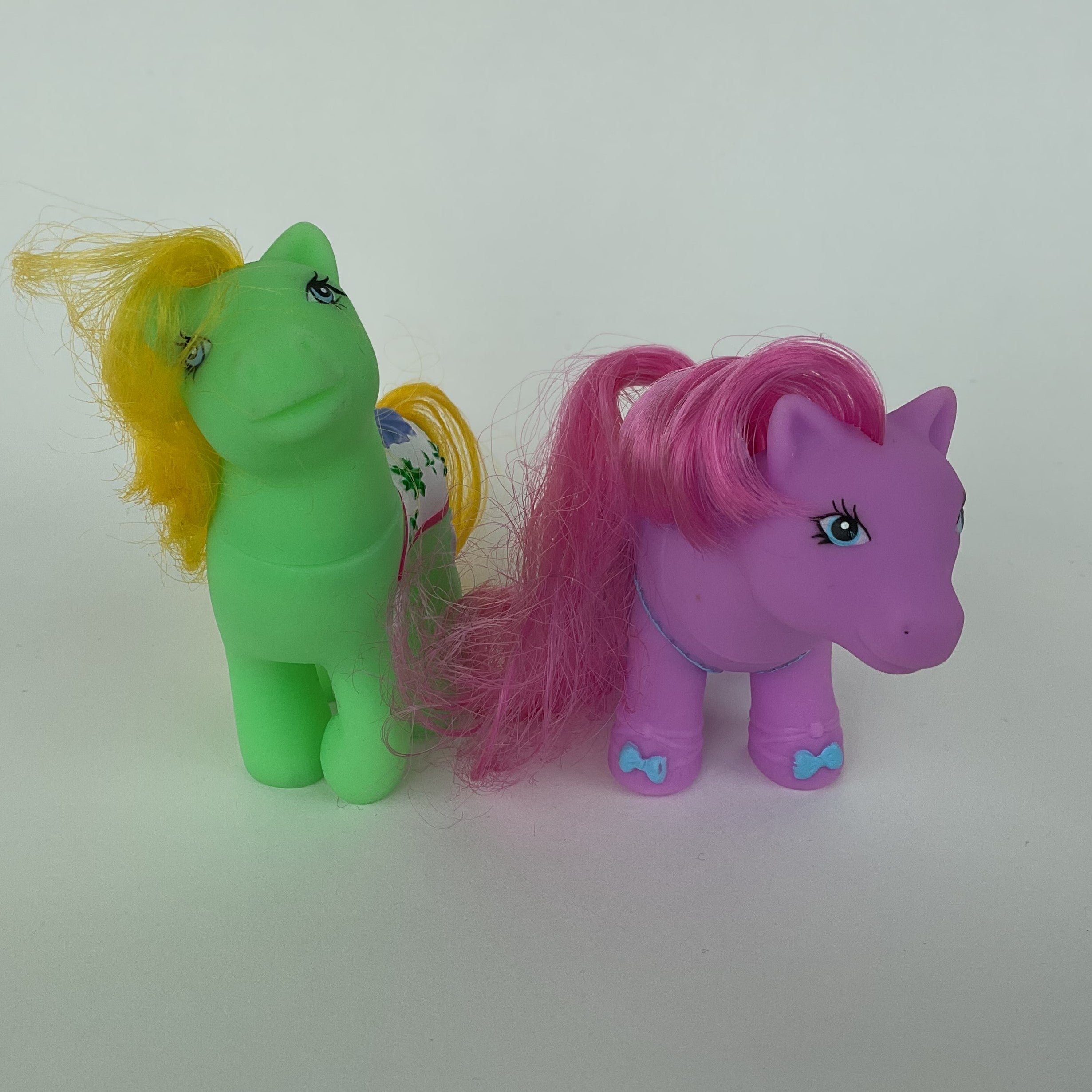 2 søde ponyfigurer med farverige detaljer – grøn/gul og lilla/pink – ca. 9 cm