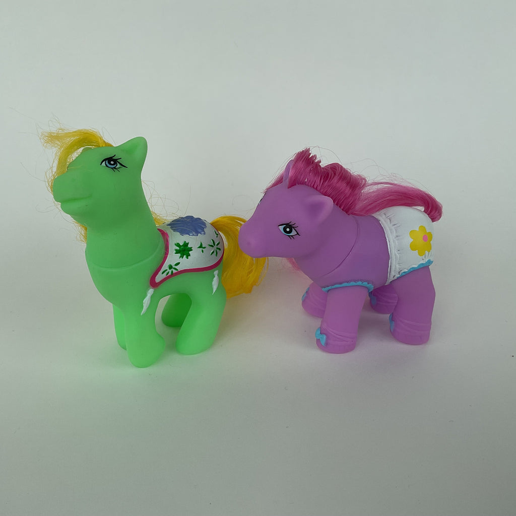 2 søde ponyfigurer med farverige detaljer – grøn/gul og lilla/pink – ca. 9 cm