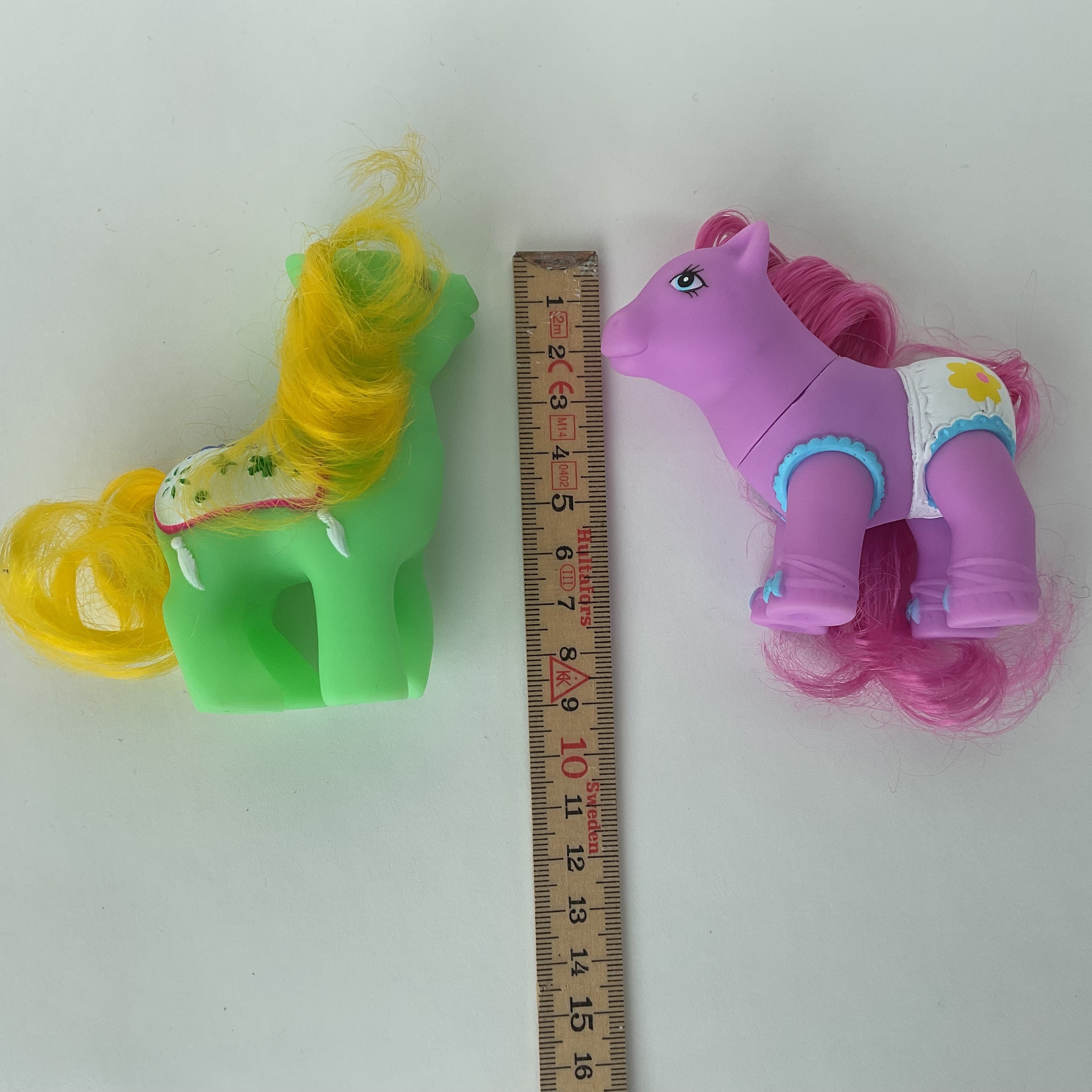 2 søde ponyfigurer med farverige detaljer – grøn/gul og lilla/pink – ca. 9 cm